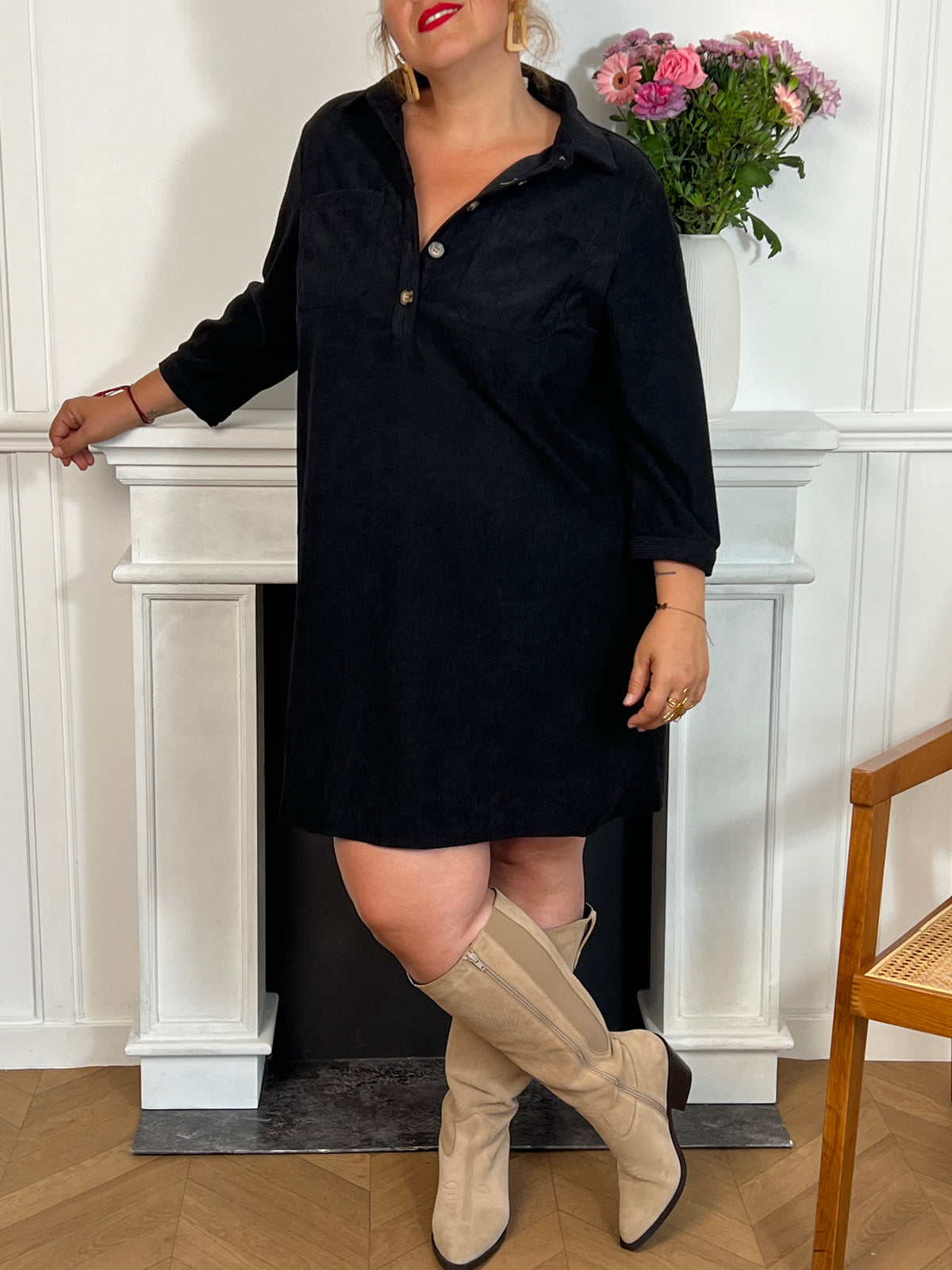 Cette robe courte noire grande taille, modèle Cora, allie élégance et confort. Ses manches longues et son col chemise apportent une touche sophistiquée, tandis que les boutons au col et aux manches accentuent son style raffiné.