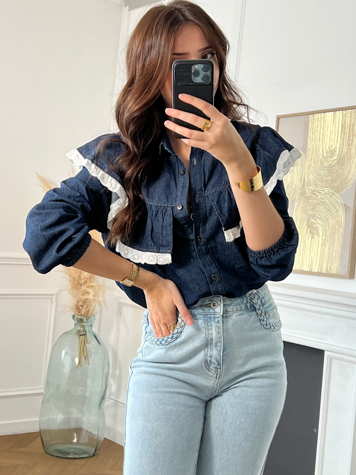 Cette chemise bleue Elyna allie élégance et confort avec son col classique et ses manches élastiques qui facilitent le mouvement. Les boutons sur toute la longueur permettent un enfilage pratique, tandis que le volant orné d'une broderie écrue apporte une touche délicate et raffinée.