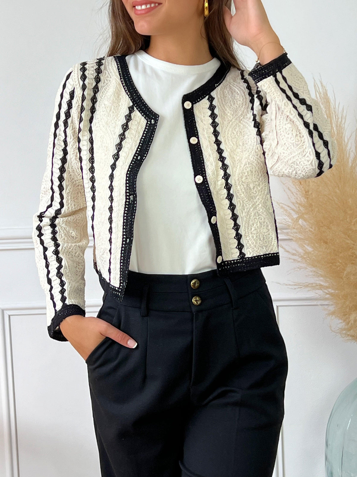 Gilet court en macramé noir et écru Manches longues Col rond Boutons sur la longueur Couleurs : écru et noir Composition : 100% Coton Made in P.R.C