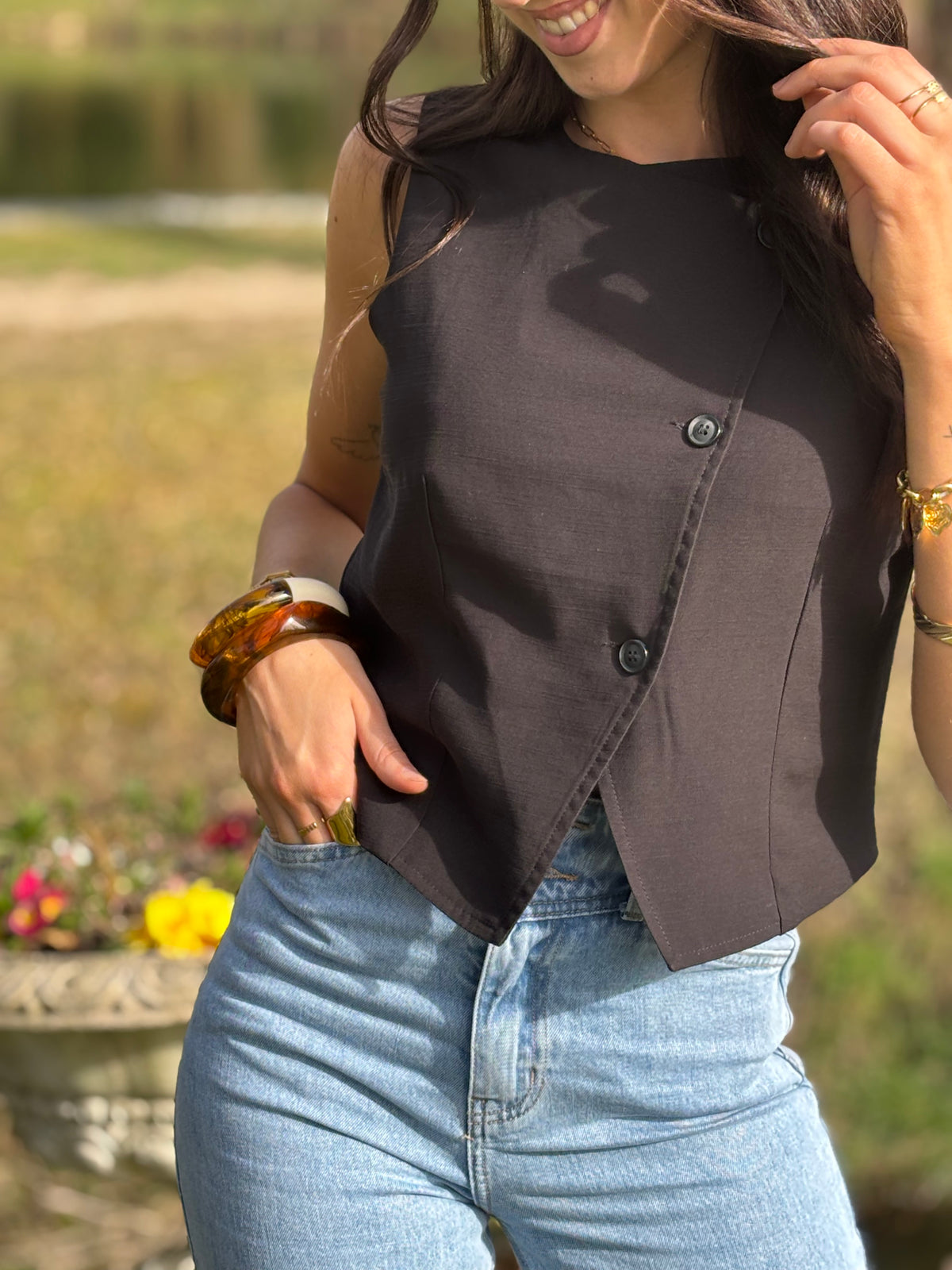 Le gilet de tailleur noir Leonie est la pièce parfaite pour compléter votre tenue formelle avec une touche de chic. Avec son design court et sans manches, ses boutons sur la longueur et son effet croisé sur le bas, il ajoute une sophistication à toute tenue. De plus, il est entièrement doublé pour un confort et une élégance optimaux. (Avec le gilet Leonie, vous serez la définition du style décontracté mais chic !)