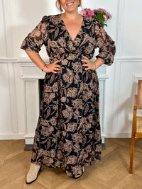 Cette robe longue à motifs Lyvia offre un confort parfait grâce à sa taille et ses poignets élastiques qui épousent délicatement toutes les silhouettes. Son col cache-cœur met en valeur le décolleté tandis que ses manches longues apportent une élégance intemporelle.