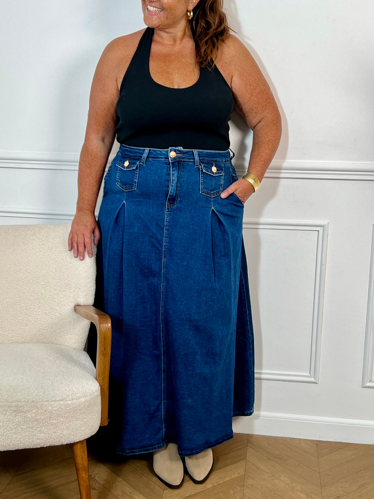 Cette jupe longue en jean bleu foncé pour offre une coupe évasée confortable. Pratique avec ses multiples poches et ses passants pour ceinture, elle se distingue par ses élégants boutons dorés.