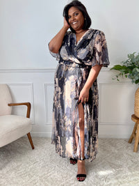 Féminine et délicate, cette robe longue doublée séduit par son col cache-cœur et ses manches courtes. Ses tons neutres de noir et beige évoquent la douceur du printemps, pour une allure romantique et raffinée.