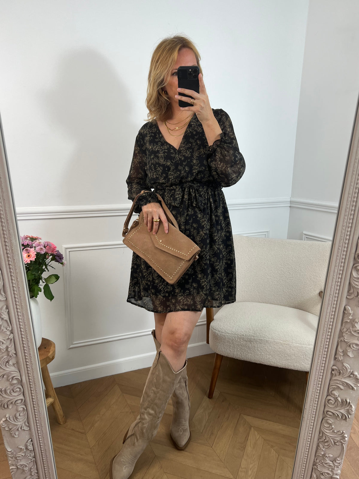 La robe courte Timy offre confort et élégance avec ses manches longues, son col cache-cœur et sa ceinture amovible. Ses motifs floraux en noir et beige donnent une touche élégante et féminine à cette pièce facile à porter au quotidien ou pour des occasions spéciales.