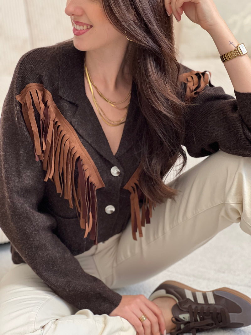 Chic et original, ce gilet marron col V se distingue par ses franges marron clair sur le devant. Une pièce pleine de caractère, à la fois douce, moderne et facile à associer au quotidien.