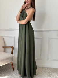 Adoptez une allure audacieuse avec cette robe longue kaki Adeje. Son col montant réglable, orné d’un détail doré, apporte une touche sophistiquée tandis que l’élastique au dos assure un confort parfait. Sans manches et à la coupe ample, elle offre une liberté de mouvement idéale pour affirmer votre style avec assurance.&nbsp;