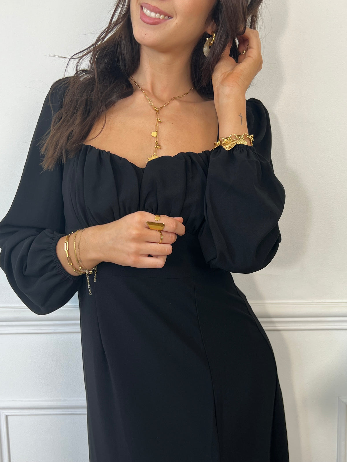 Plongez dans l'élégance avec notre robe longue noire Rosalie. Les manches longues et le col carré ajoutent une touche moderne, tandis que les volants au niveau de la poitrine offrent une allure féminine.