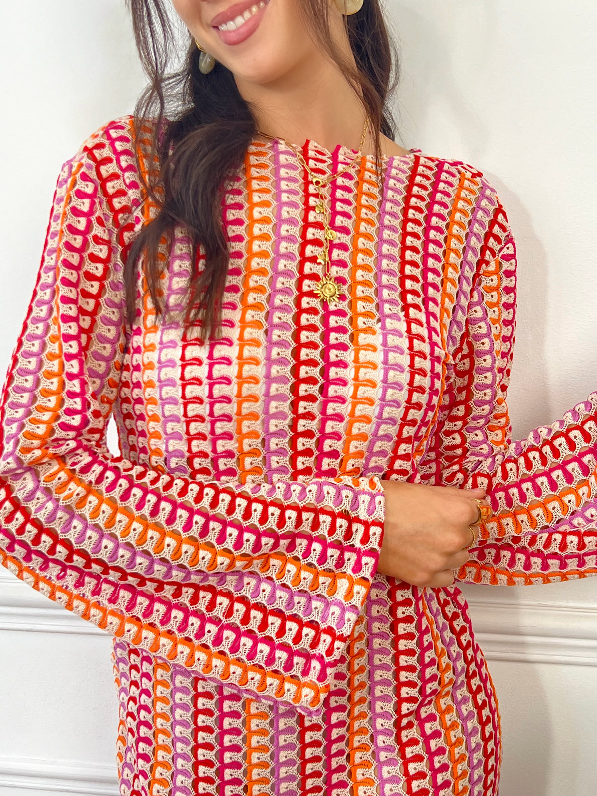 Cette robe ajourée aux nuances de rose et de orange est l’essence même de la légèreté estivale. Son tissu délicatement travaillé laisse respirer la peau, offrant une sensation de fraîcheur idéale pour les journées ensoleillées. À la fois élégante et décontractée, elle sublime la silhouette tout en apportant une touche bohème et raffinée.