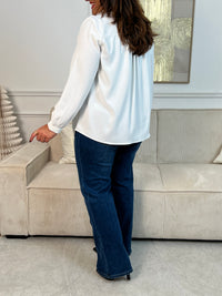 Élégante et délicate, cette chemise écrue fluide se distingue par ses volants au col, apportant une touche de féminité et de charme. Une pièce chic et intemporelle, parfaite pour sublimer n’importe quel look.