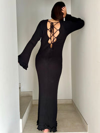 La robe longue noir Esther est un mariage parfait de chic et de confort. Avec ses manches longues et son col rond, elle assure une élégance intemporelle. Mais le dos nu avec lacets croisés et les volants aux manches et au bas de la robe ajoutent une touche ludique et originale. Soyez prête à faire tourner les têtes avec cette robe unique !