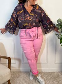 Ce pantalon stretch rose allie confort et style. Sa taille élastique et sa ceinture amovible offrent un ajustement parfait. Avec sa coupe fluide, ses poches pratiques et son tissu extensible, il flatte toutes les silhouettes et s’adapte à toutes vos envies, chic ou décontractées.