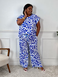 Léger et éclatant, ce top fluide bleu et écru sans manches séduit par ses jolis volants aux épaules. Une pièce pleine de fraîcheur et de féminité, parfaite pour égayer vos looks avec une touche raffinée.