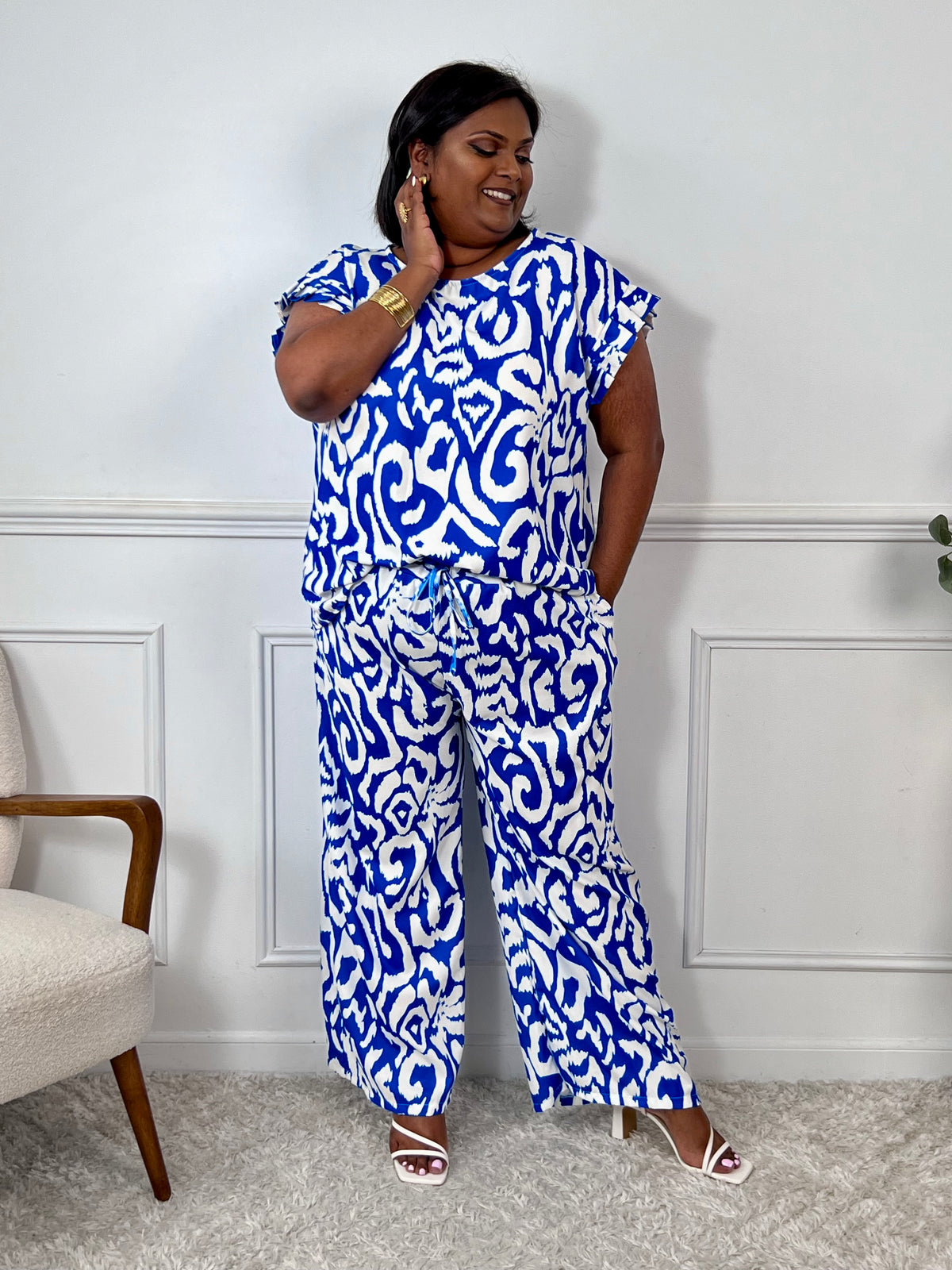 Léger et éclatant, ce top fluide bleu et écru sans manches séduit par ses jolis volants aux épaules. Une pièce pleine de fraîcheur et de féminité, parfaite pour égayer vos looks avec une touche raffinée.