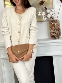 La veste écrue et dorée incarne l'élégance avec une touche luxueuse. Ses accents dorés subtils ajoutent une allure sophistiquée à cette pièce classique. Parfaitement coupée pour flatter les formes, cette veste devient un incontournable pour celles qui recherchent style et confort.