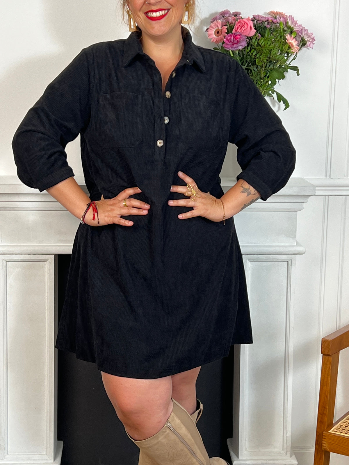 Cette robe courte noire grande taille, modèle Cora, allie élégance et confort. Ses manches longues et son col chemise apportent une touche sophistiquée, tandis que les boutons au col et aux manches accentuent son style raffiné.
