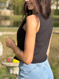 Le gilet de tailleur noir Leonie est la pièce parfaite pour compléter votre tenue formelle avec une touche de chic. Avec son design court et sans manches, ses boutons sur la longueur et son effet croisé sur le bas, il ajoute une sophistication à toute tenue. De plus, il est entièrement doublé pour un confort et une élégance optimaux. (Avec le gilet Leonie, vous serez la définition du style décontracté mais chic !)