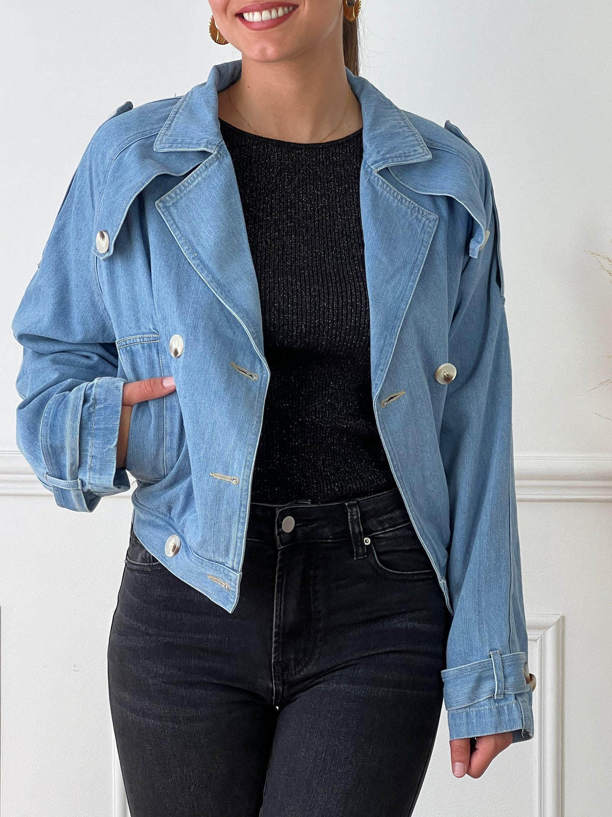 Veste courte en jean bleue Manches longues Boutons sur la longueur et aux poignets 2 poches latérales Ceinture amovible avec passants Boutons sur les poches, à la poitrine, aux épaules et aux poignets Couleur : bleu clair Composition : 100% Coton Made in P.C.R