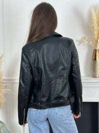 La veste style perfecto noir Cori est la pièce parfaite pour ajouter une touche de style à votre tenue. Avec sa fermeture éclair argentée et sa coupe cintrée, elle apporte une allure moderne et élégante. La ceinture amovible en bas permet d'ajuster la veste à votre goût, offrant confort et style.