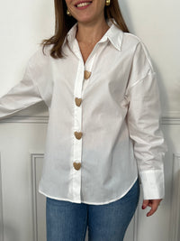 Montrez votre élégance avec la chemise écrue femme Cecilia. Ses manches longues et son col chemise vous donnent une allure professionnelle. Les boutons en forme de coeur sur le devant et aux poignets ajoutent une touche de féminité. Cette chemise est un must-have pour toute garde-robe.