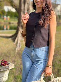 Le gilet de tailleur noir Leonie est la pièce parfaite pour compléter votre tenue formelle avec une touche de chic. Avec son design court et sans manches, ses boutons sur la longueur et son effet croisé sur le bas, il ajoute une sophistication à toute tenue. De plus, il est entièrement doublé pour un confort et une élégance optimaux. (Avec le gilet Leonie, vous serez la définition du style décontracté mais chic !)