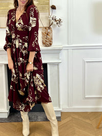 Robe longue bordeaux élégante aux détails dorés, idéale pour les occasions spéciales. Son col V et ses manches longues apportent une touche raffinée, tandis que l’élastique au dos assure un confort parfait. Entièrement doublée jusqu’à mi-longueur, elle allie style et aisance dans des nuances subtiles de bordeaux et doré.