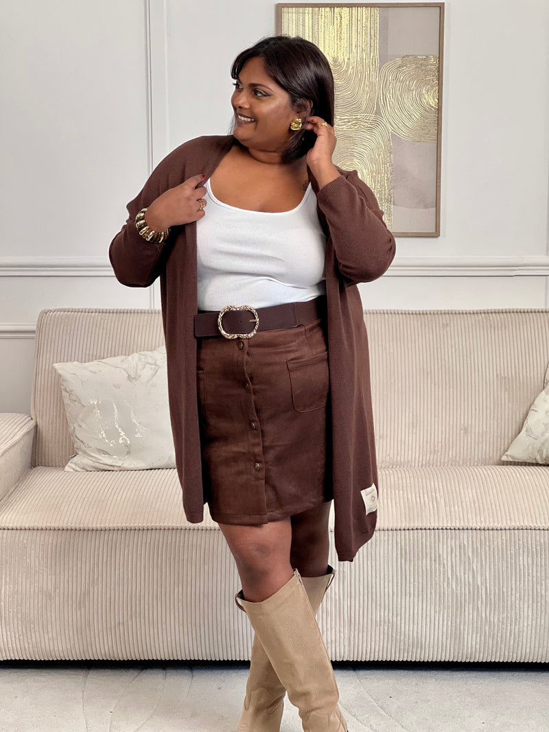 Douce et tendance, cette jupe courte marron effet daim séduit par sa texture veloutée et sa rangée de boutons sur le devant. Une pièce chic et intemporelle, parfaite pour un look automnal raffiné.