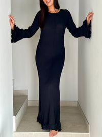 La robe longue noir Esther est un mariage parfait de chic et de confort. Avec ses manches longues et son col rond, elle assure une élégance intemporelle. Mais le dos nu avec lacets croisés et les volants aux manches et au bas de la robe ajoutent une touche ludique et originale. Soyez prête à faire tourner les têtes avec cette robe unique !