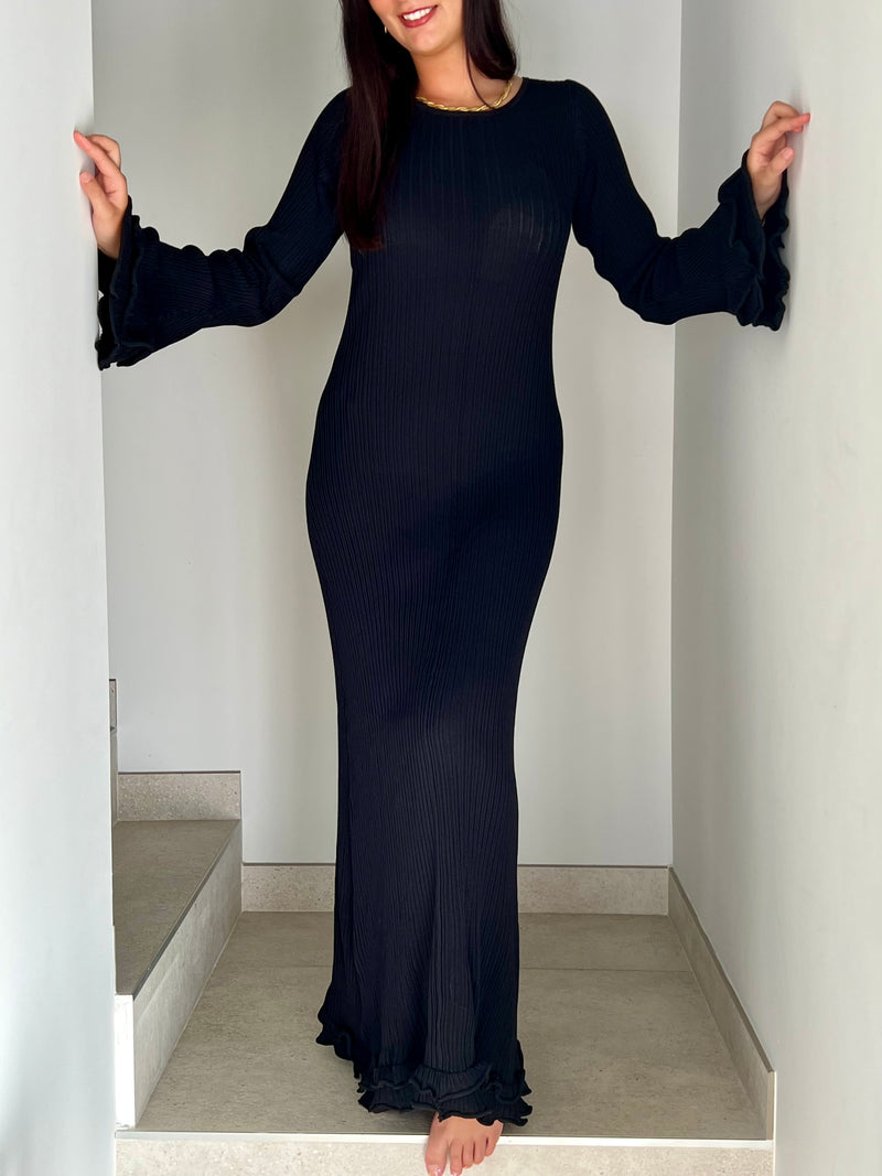 La robe longue noir Esther est un mariage parfait de chic et de confort. Avec ses manches longues et son col rond, elle assure une élégance intemporelle. Mais le dos nu avec lacets croisés et les volants aux manches et au bas de la robe ajoutent une touche ludique et originale. Soyez prête à faire tourner les têtes avec cette robe unique !