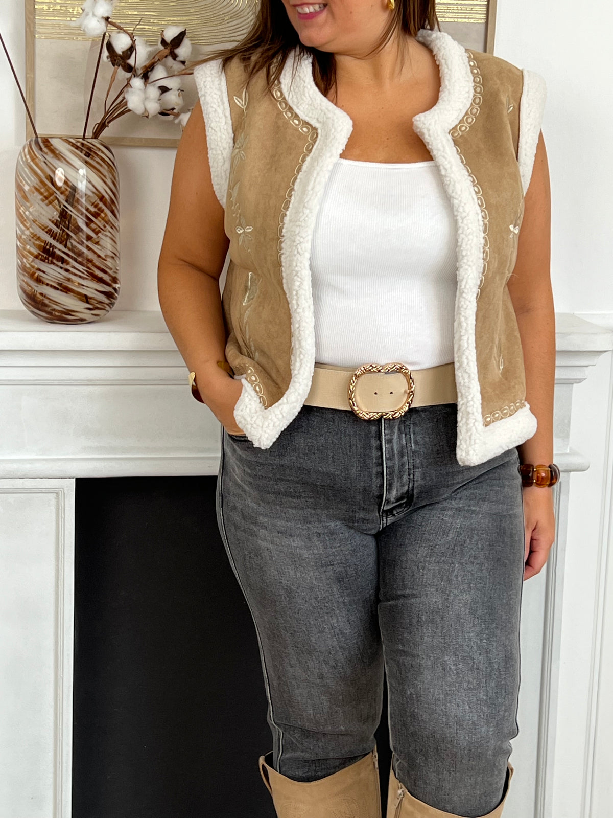 Cette veste sans manches camel Maelia combine douceur et style avec sa moumoute chaleureuse et son col rond confortable. Les motifs floraux apportent une touche féminine et délicate, idéale pour rehausser vos tenues tout en restant confortable.