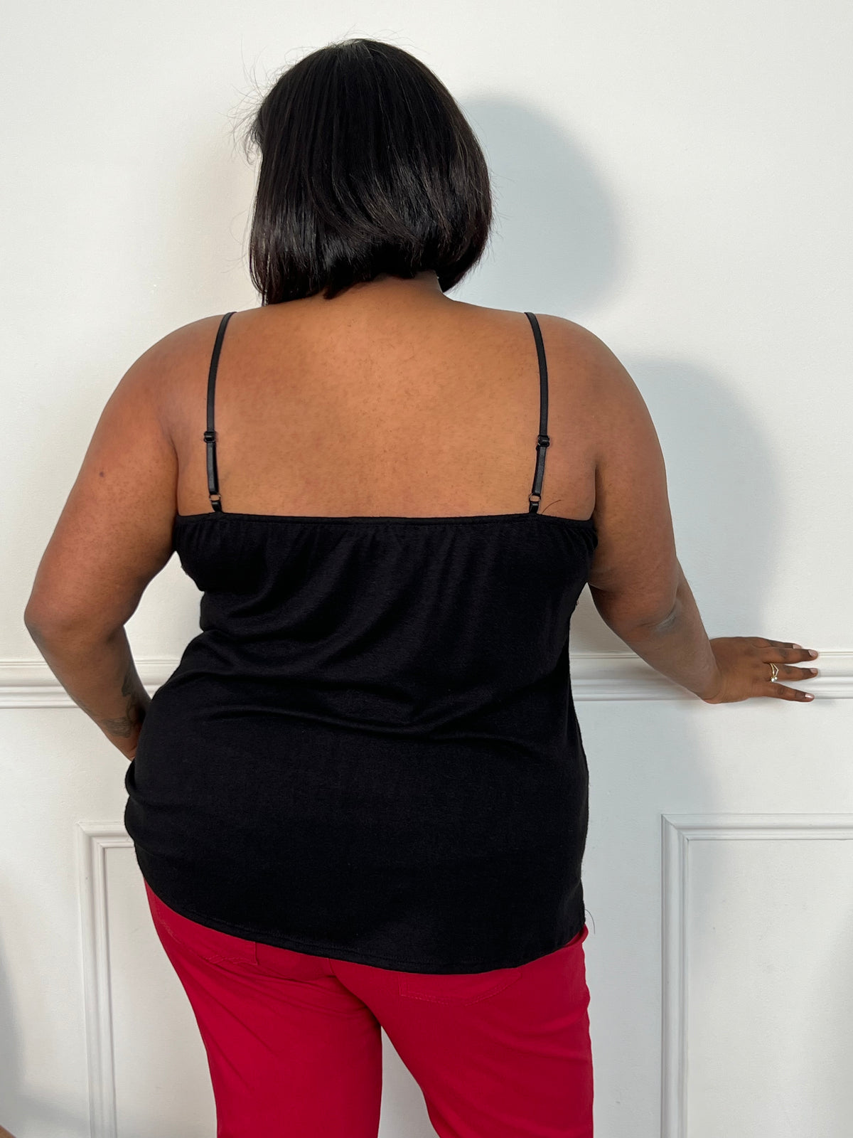 Sublimez votre allure avec ce top noir, orné d'une délicate dentelle sur son col V et doté de bretelles réglables pour un ajustement parfait. Élégance et féminité au rendez-vous.