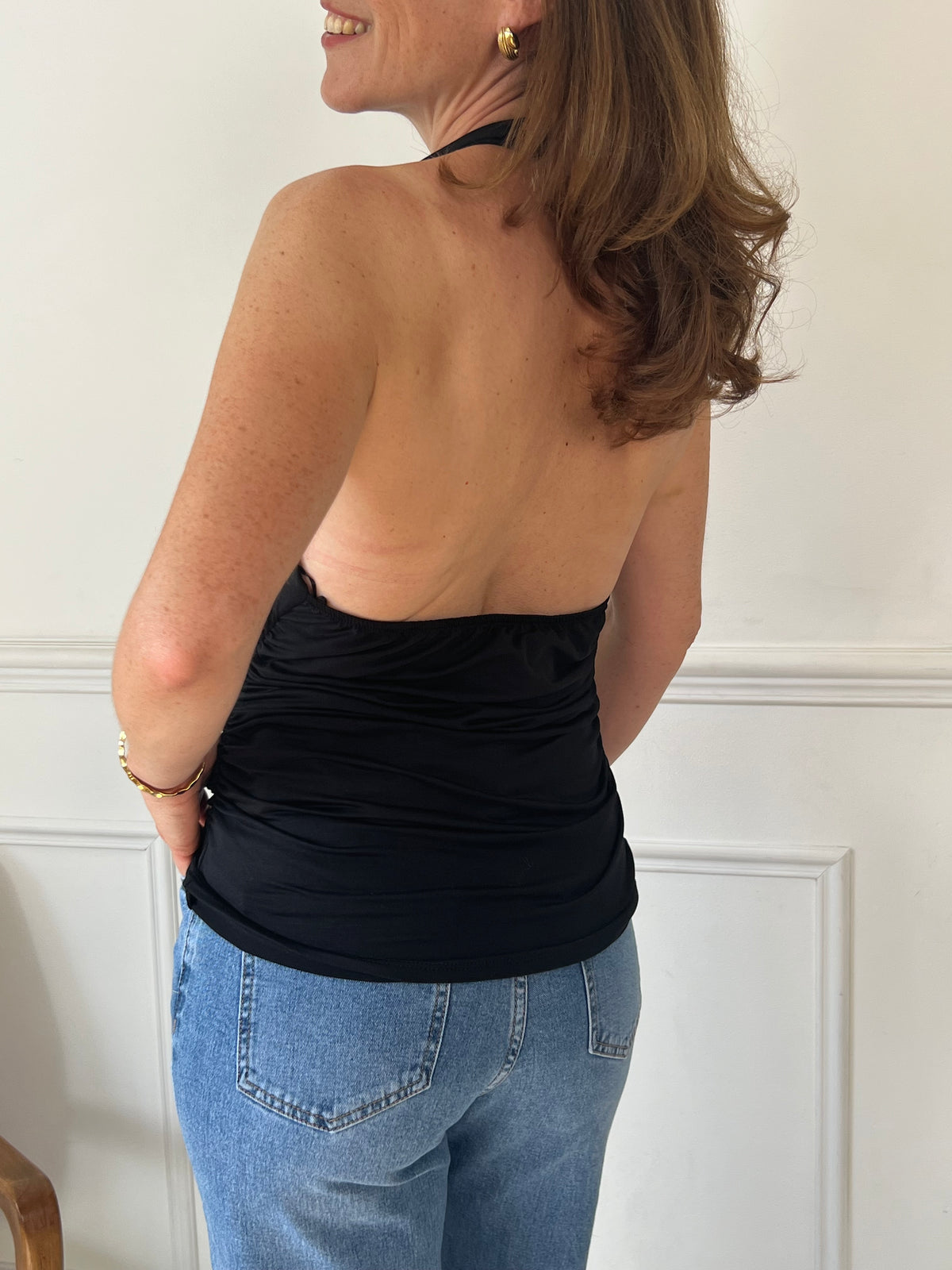 Ce top noir sans manches met en valeur votre silhouette avec son dos nu élégant et son drapé délicat. Sa coupe fluide assure un confort optimal tout en apportant une touche sophistiquée à vos tenues. Parfait pour les occasions où vous souhaitez allier style et aisance.