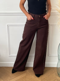 Découvrez notre jean marron coupe Studs Wide Leg, un modèle tendance avec des détails de clous élégants sur les côtés. Ce jean allie confort et style grâce à ses 2 poches avant, 2 poches arrière et ses passants pour ceinture. Sa coupe moderne et sa couleur marron intemporelle en font une pièce unique à intégrer à votre dressing.