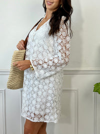 Une pièce féminine et élégante. Avec ses manches longues évasées et son col V orné de volants, cette robe en broderie ajourée est un véritable plaisir pour les yeux. Les boutons dorés et écrus ajoutent une touche de glamour, tandis que la doublure en bretelles assure un confort optimal.