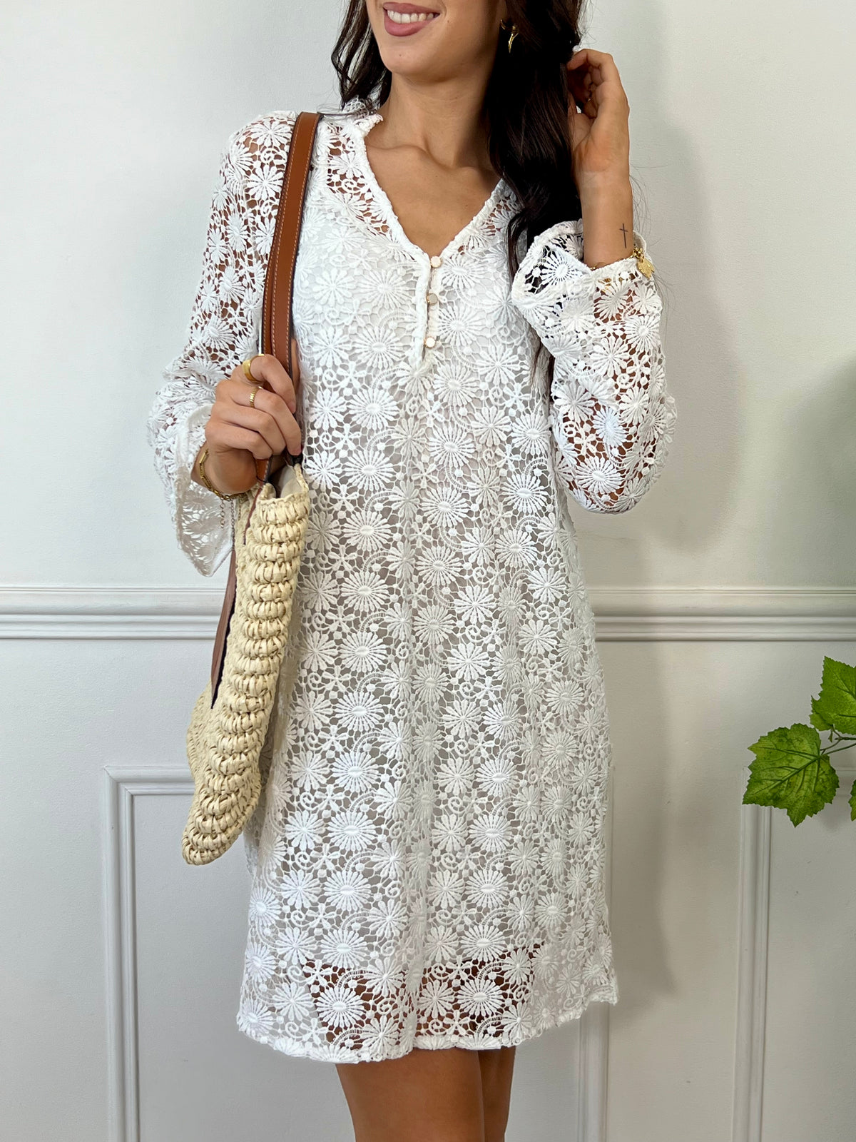 Une pièce féminine et élégante. Avec ses manches longues évasées et son col V orné de volants, cette robe en broderie ajourée est un véritable plaisir pour les yeux. Les boutons dorés et écrus ajoutent une touche de glamour, tandis que la doublure en bretelles assure un confort optimal.
