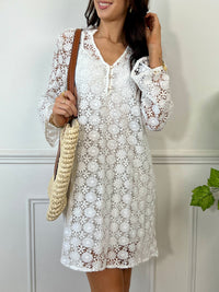 Une pièce féminine et élégante. Avec ses manches longues évasées et son col V orné de volants, cette robe en broderie ajourée est un véritable plaisir pour les yeux. Les boutons dorés et écrus ajoutent une touche de glamour, tandis que la doublure en bretelles assure un confort optimal.