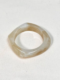 Le bracelet Lorylyn est une pièce en résine beige et écru. Son design original apporte une touche de fantaisie à votre tenue. Léger et confortable, il ajoutera une touche de style à votre look.
