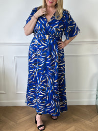 Cette robe s'étend jusqu'aux pieds et est ornée de motifs bleus, ce qui lui confère un style distinctif. La ceinture peut être utilisée pour marquer la taille et ajouter une touche de structure à la silhouette. Cette tenue est parfaite pour des occasions spéciales ou pour un look décontracté mais chic.