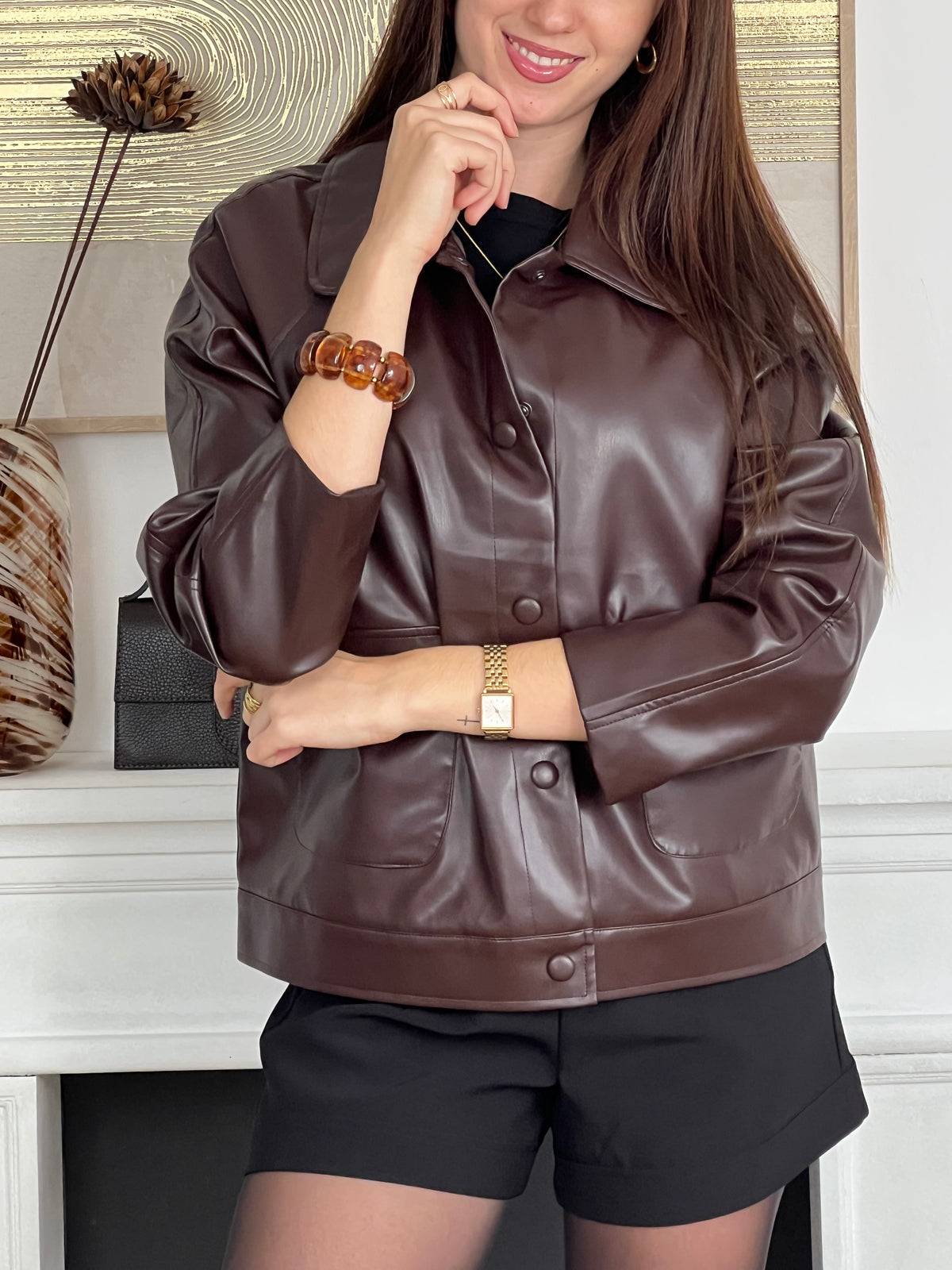 Élégante et originale, cette veste marron aux légers reflets bordeaux séduit par son jeu de nuances raffinées. Dotée de deux poches pratiques à l’avant, elle allie style et fonctionnalité pour sublimer vos looks du quotidien.