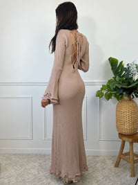La robe longue beige Esther est un mariage parfait de chic et de confort. Avec ses manches longues et son col rond, elle assure une élégance intemporelle. Mais le dos nu avec lacets croisés et les volants aux manches et au bas de la robe ajoutent une touche ludique et originale. Soyez prête à faire tourner les têtes avec cette robe unique !