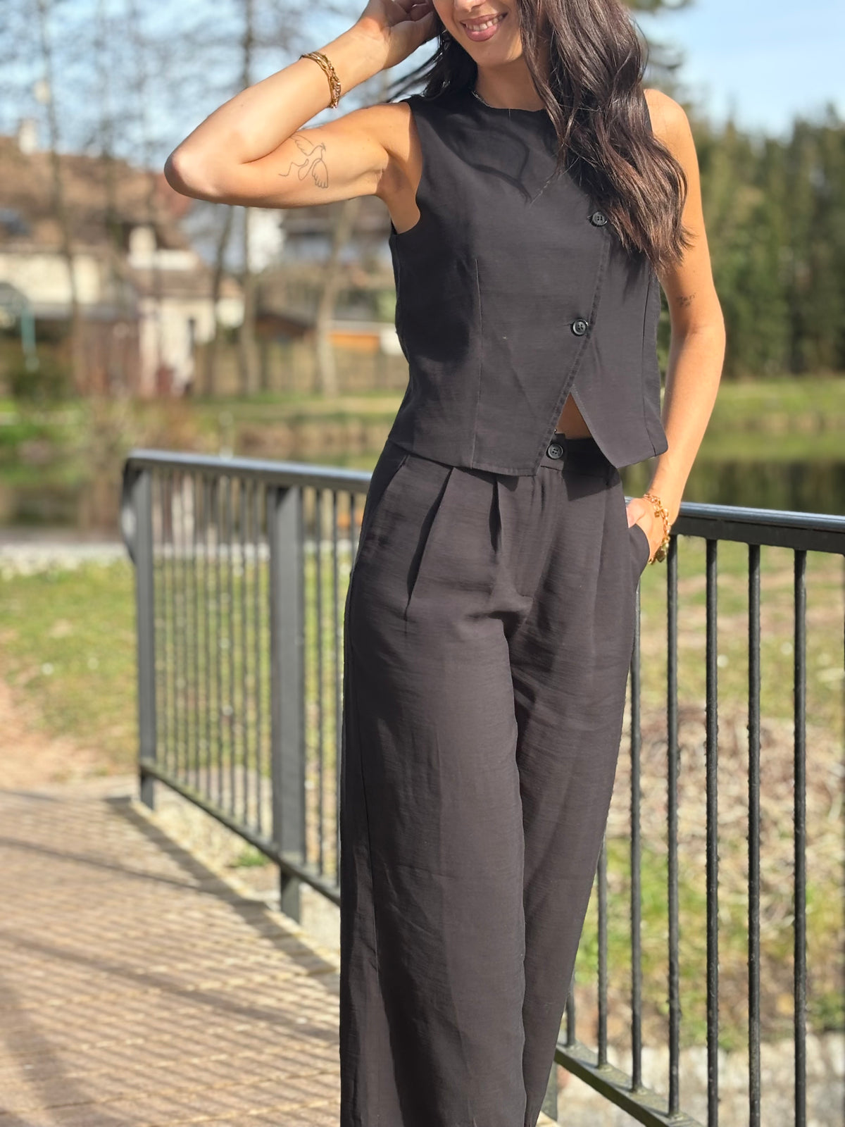 Le gilet de tailleur noir Leonie est la pièce parfaite pour compléter votre tenue formelle avec une touche de chic. Avec son design court et sans manches, ses boutons sur la longueur et son effet croisé sur le bas, il ajoute une sophistication à toute tenue. De plus, il est entièrement doublé pour un confort et une élégance optimaux. (Avec le gilet Leonie, vous serez la définition du style décontracté mais chic !)
