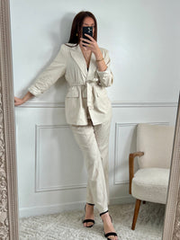 Optez pour un look chic et élégant avec notre blazer beige Salome pour femme ! Avec sa ceinture amovible et ses épaulettes, il mettra en valeur votre silhouette tout en vous offrant une allure sophistiquée. Doté d'un bouton et de 2 poches factices à l'avant, il est aussi pratique qu'élégant. Doublé pour un confort optimal, il apportera une touche tendance à votre tenue. À associer avec le pantalon Salome pour un look complet.