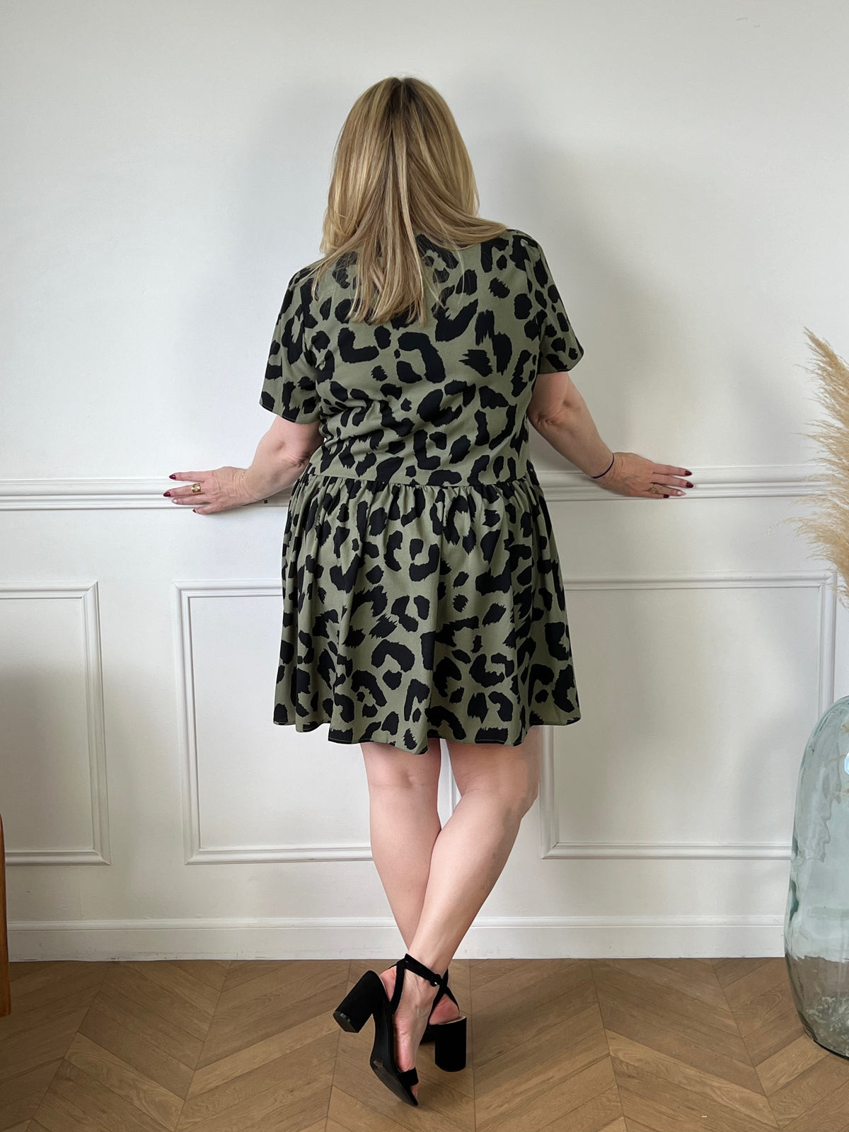 Offrez-vous un look frais et élégant avec notre robe courte kaki à motif Romie. Avec sa coupe ample et ses motifs noirs, elle vous donnera un style unique et confortable. Parfaite pour toutes les occasions, cette robe est un must-have pour votre garde-robe!