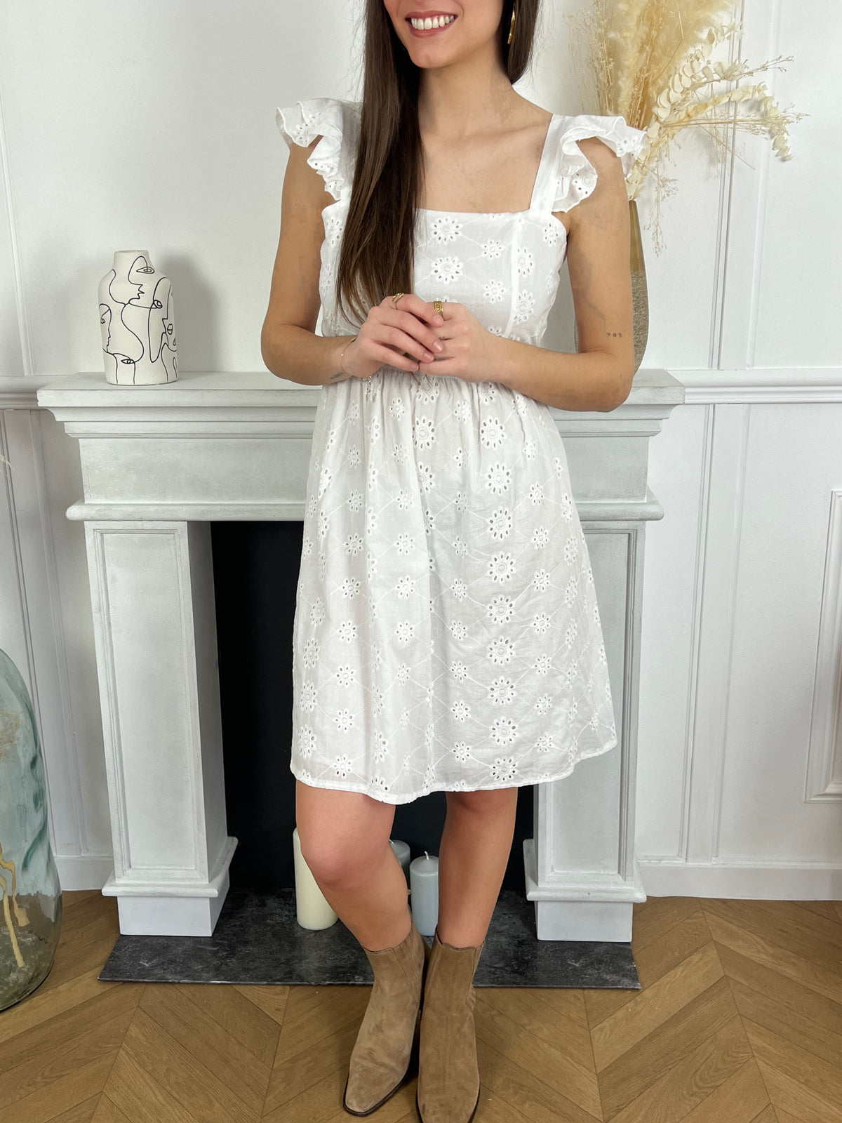 Découvrez la robe Belva, parfaite pour l'été avec son design sans manches et ses volants élégants. Les motifs brodés ajoutent une touche de sophistication tandis que la teinte écru apporte une touche de fraîcheur à votre tenue. Profitez d'un style chic et confortable grâce à cette robe.