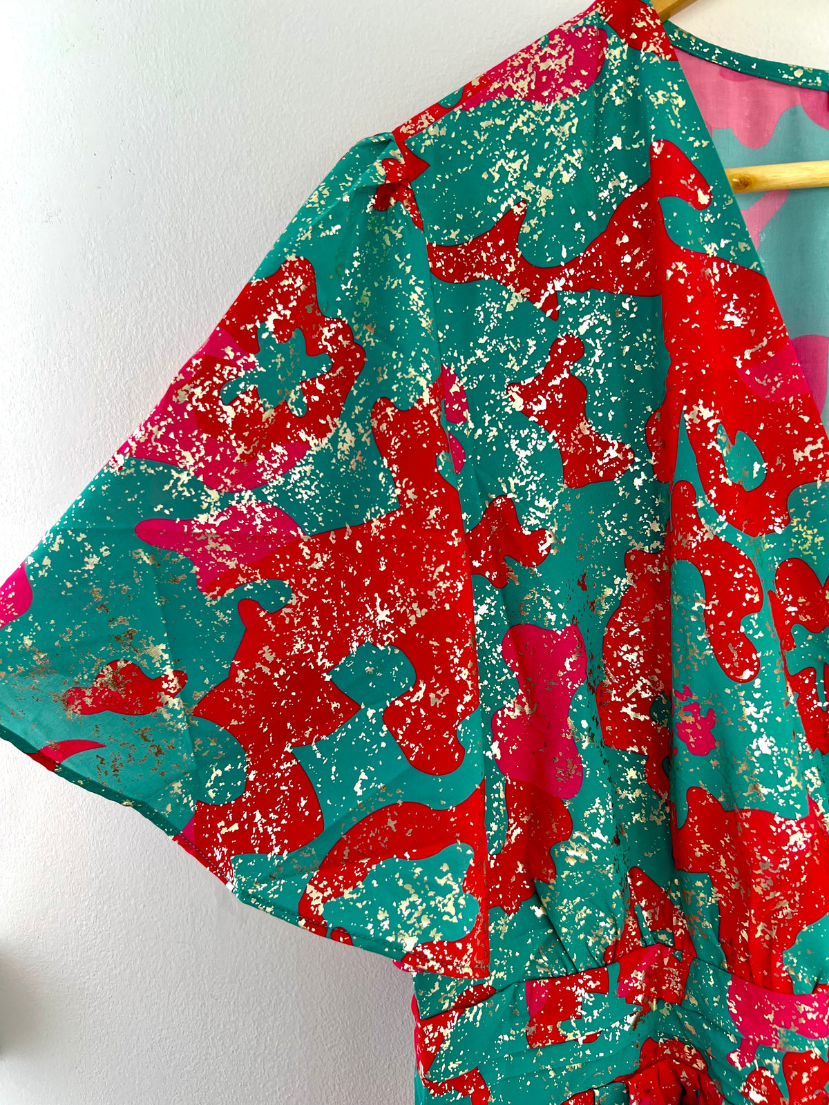 Plongez dans un tourbillon de couleurs avec cette robe vibrante, mêlant des tons de vert, de rose et de rouge. Sa palette audacieuse évoque la joie et la vitalité, tandis que sa coupe flatteuse met en valeur votre silhouette avec élégance.