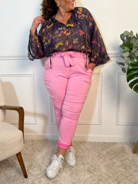Ce pantalon stretch rose allie confort et style. Sa taille élastique et sa ceinture amovible offrent un ajustement parfait. Avec sa coupe fluide, ses poches pratiques et son tissu extensible, il flatte toutes les silhouettes et s’adapte à toutes vos envies, chic ou décontractées.