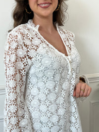 Une pièce féminine et élégante. Avec ses manches longues évasées et son col V orné de volants, cette robe en broderie ajourée est un véritable plaisir pour les yeux. Les boutons dorés et écrus ajoutent une touche de glamour, tandis que la doublure en bretelles assure un confort optimal.