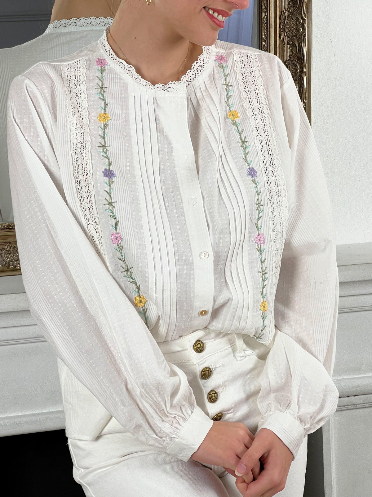 Chemise blanche manches longues avec broderie Chemise manches longues Col rond Transparente et ajourée Boutons blancs sur la longueur et aux manches Broderie sur le devant et au col Couleur : écru Détail motif floral Composition : 100%  coton Made in P.R.C