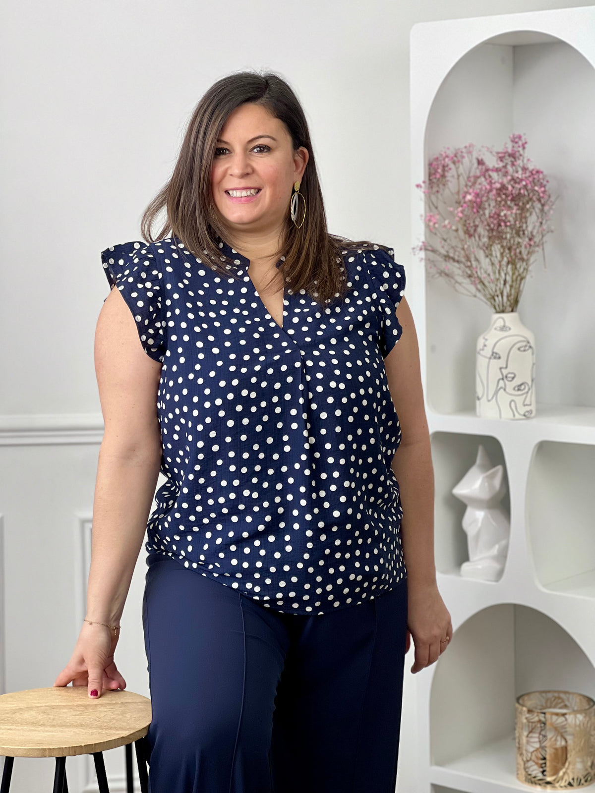 Blouse à motifs grande taille femme, idéale pour une tenue légère et féminine. Sans manches, avec un col V et des volants aux épaules, elle apporte une touche élégante et tendance. Ses motifs pois bleu et écru ajoutent du charme et du style à vos looks. Facile à porter, cette blouse est parfaite pour un look estival chic et décontracté.