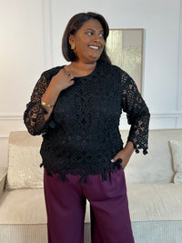 Cette blouse noire est ornée de broderies délicates, avec des manches longues en broderie et un col rond. Pratique avec ses boutons au dos et doublée à l'avant, elle ajoute une touche de délicatesse à votre garde-robe avec ses détails ajourés.