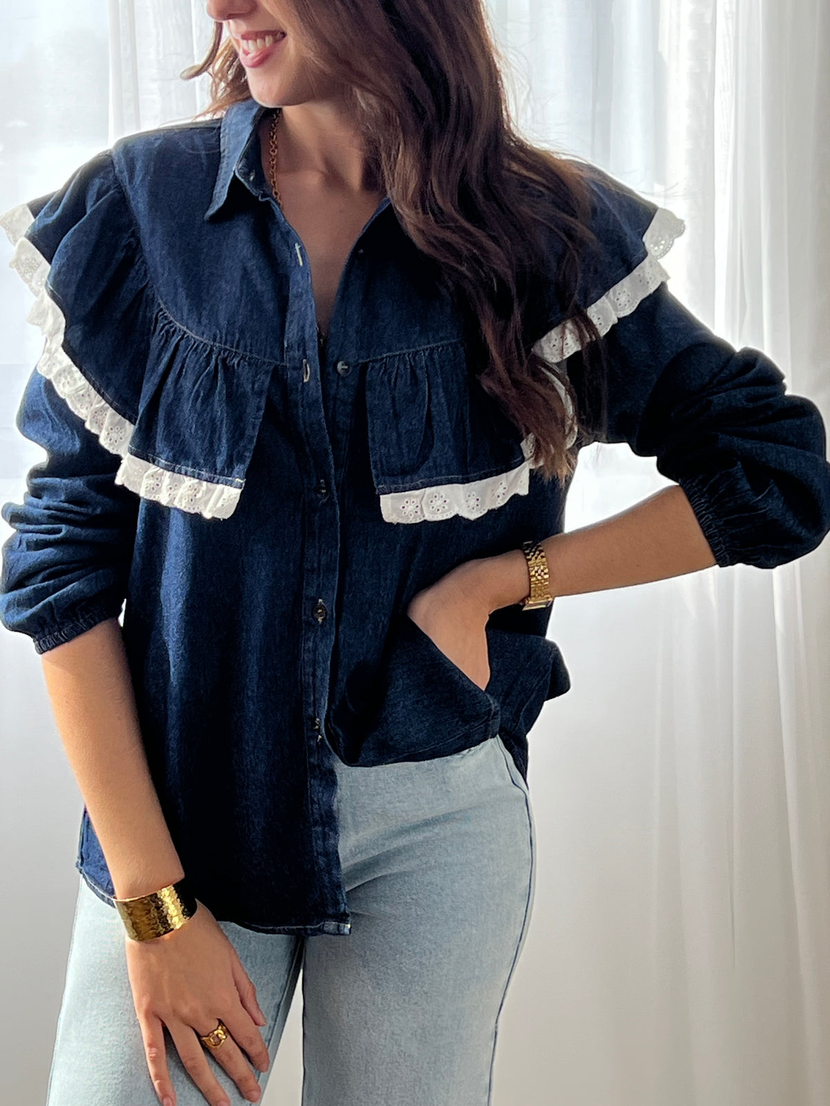 Cette chemise bleue Elyna allie élégance et confort avec son col classique et ses manches élastiques qui facilitent le mouvement. Les boutons sur toute la longueur permettent un enfilage pratique, tandis que le volant orné d'une broderie écrue apporte une touche délicate et raffinée.